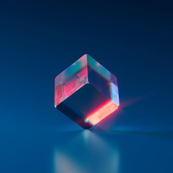 A glass cube floating above a surface, with red light glowing at certain points.